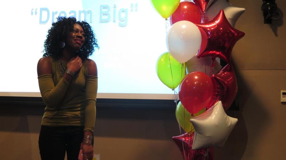 Amber Grace, who won a full scholarship at the University of Phoenix to get her master’s degree, reacts to seeing her mom surprise her with flowers during the announcement at Bealls on Friday.