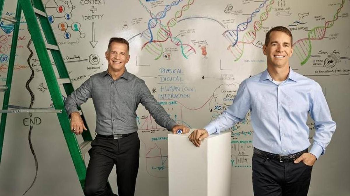 Michael Jungen, left, Carnival Corp.’s vice president of design and technology, and John Padgett, the cruise company’s chief experience and innovation officer, in front of the “genome wall,” which outlines the thinking behind the medallion technology, at Carnival Corp.’s Experience and Innovation Center in Doral.