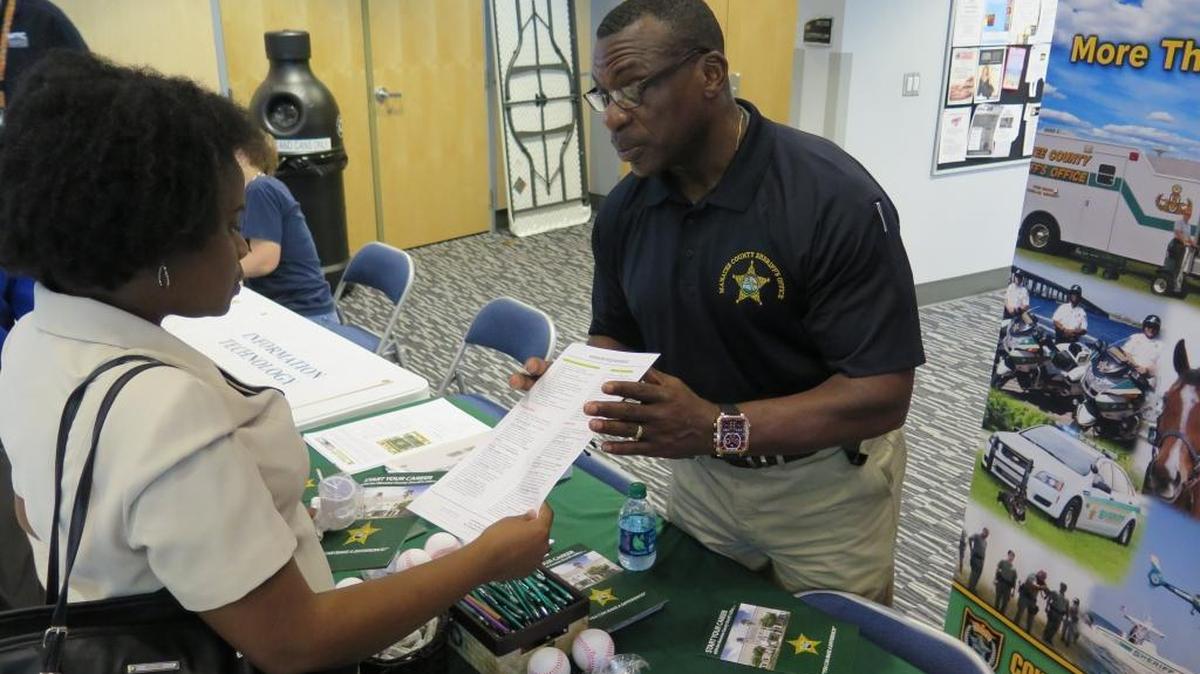 John Murrell, a recruiter for the Manatee County Sheriff’s Office, speaks to Marie Francois Wednesday at the third annual Career and Hiring Fest held by MTC in partnership with CareerSource Suncoast.