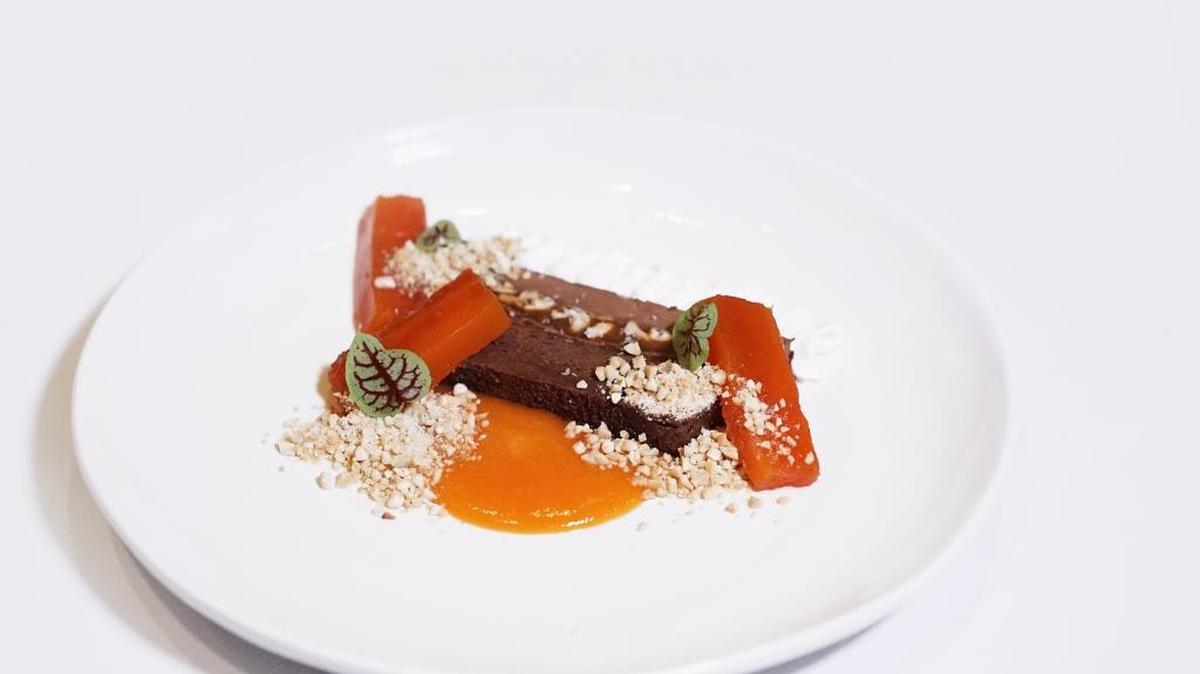 Chef Louis Robinson’s flour-less chocolate cake, made with duck fat and garnished with a compressed papaya-lime sauce, allspice cream and toasted cashews.