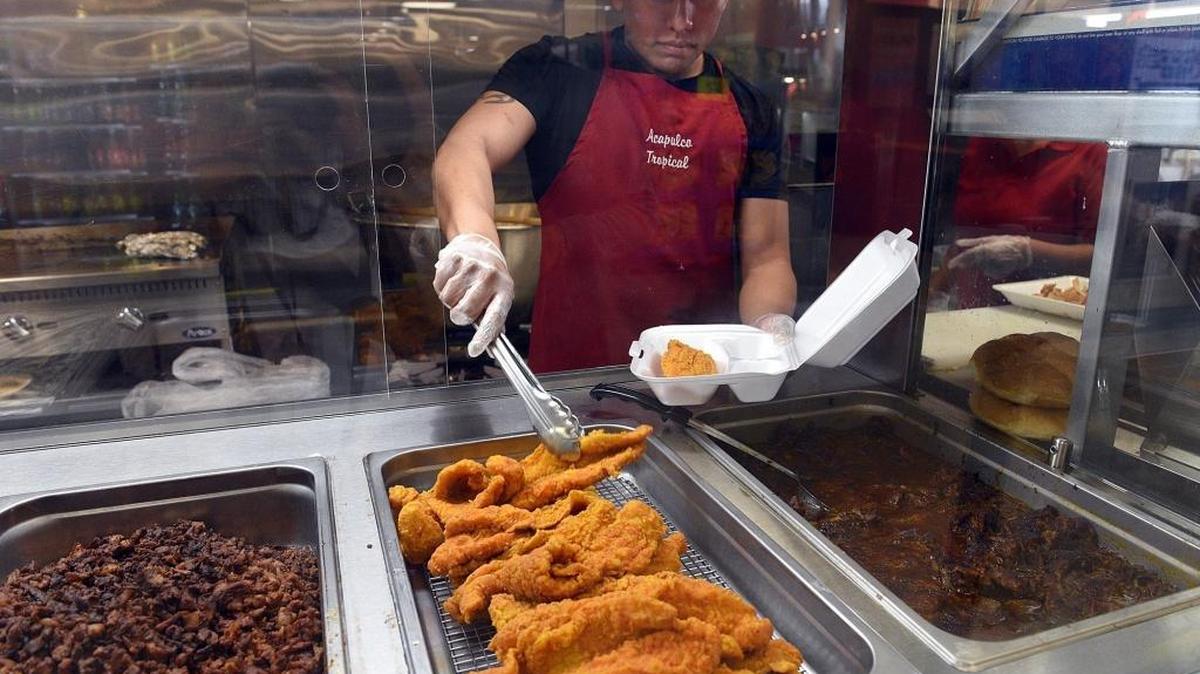 A worker serves up food from the kitchen at Acapulco Tropical in Bradenton.