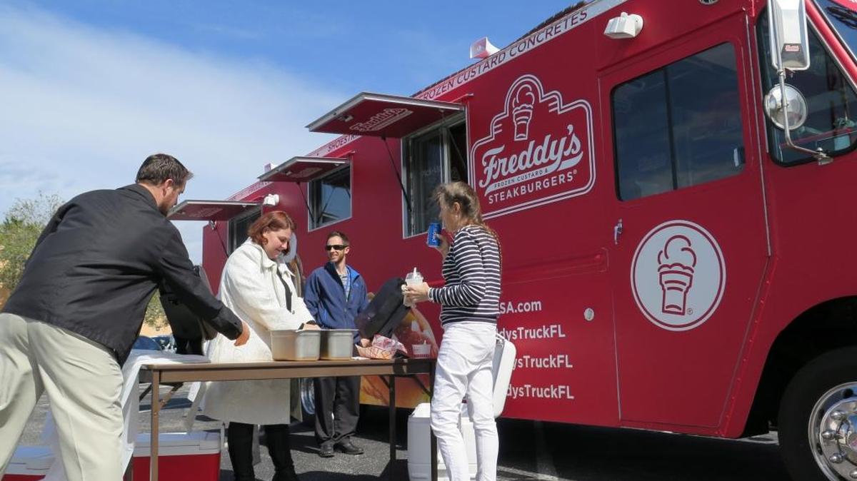 Diners line up at a Freddy’s Steakburgers food truck during a visit the truck made to downtown Bradenton in February. The truck was only stopped for one day and doesn’t have a place to come back to because of the City of Bradenton regulations surrounding food trucks.