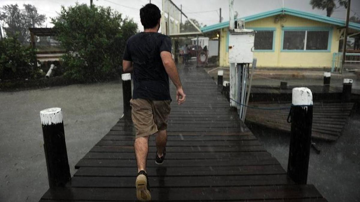 Jesse Woodson runs for cover at Tide Tables restaurant, as a heavy rain squall from Tropical Storm Colin moves over Cortez on Tuesday.