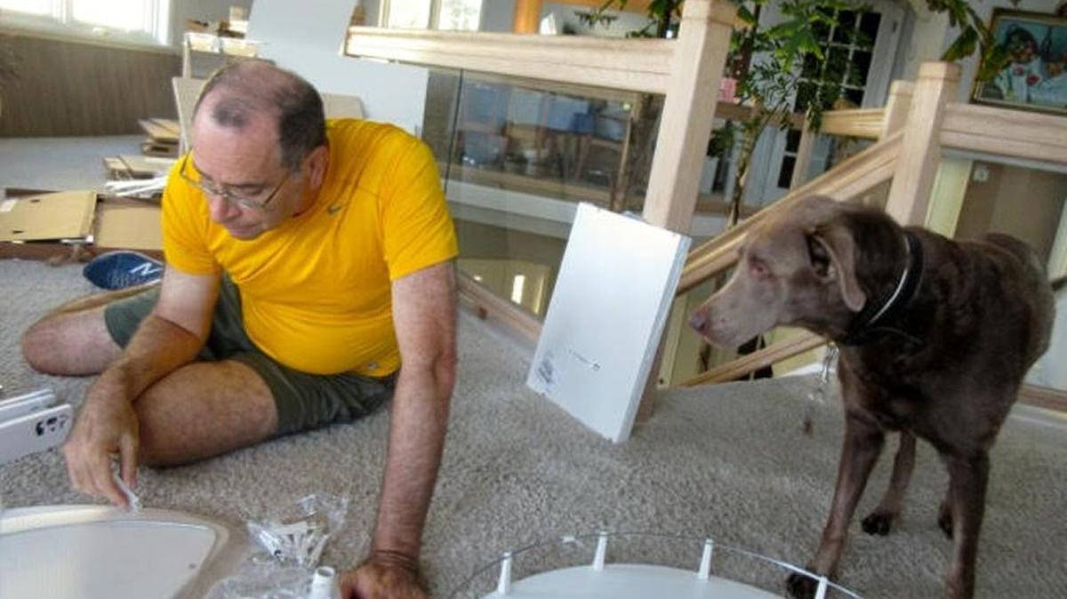 Under a watchful eye, Jim Germer works on his kitchen remodeling project.