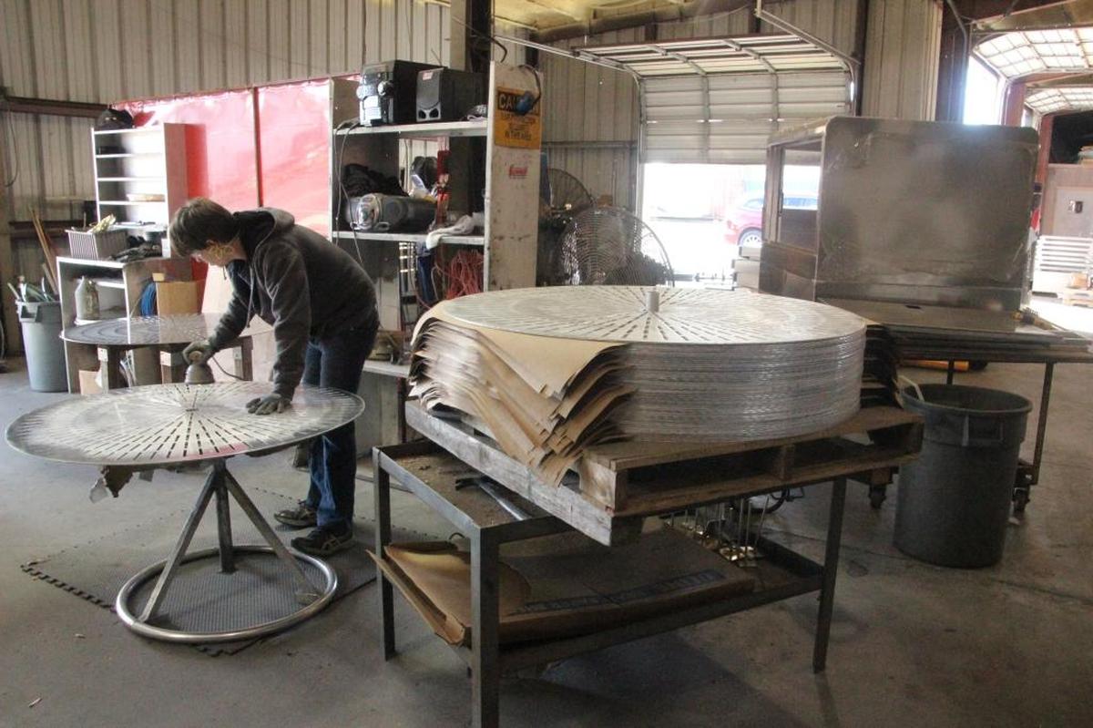 A worker prepares patio table tops at Edmunds Metal Works. The company manufactures a wide variety of metal products.