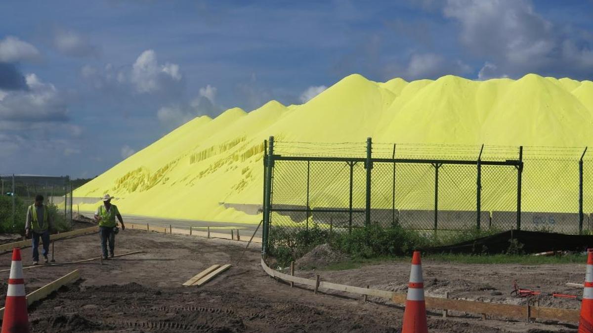 GHD, an engineering and construction firm, is the independent contractor responsible for creating a pathway to the pile of sulphur seen in this photograph. The bright yellow material is shipped in by Mosaic for use in making fertilizer.