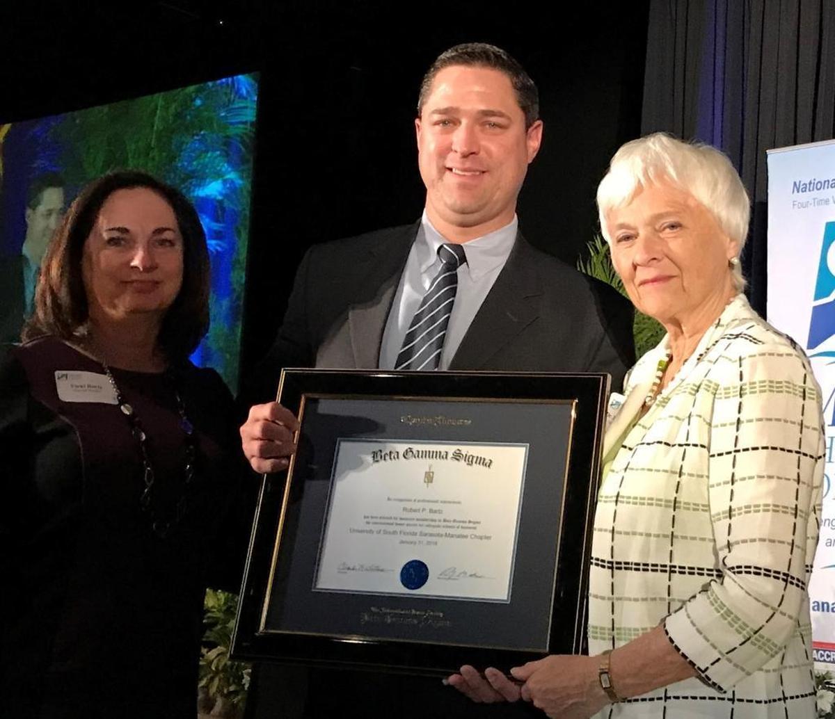 USF Sarasota-Manatee Regional Chancellor Karen Holbrook presented the Beta Sigma Gamma Award in honor of Bob Bartz to his wife, Vicki, and son, Jason.