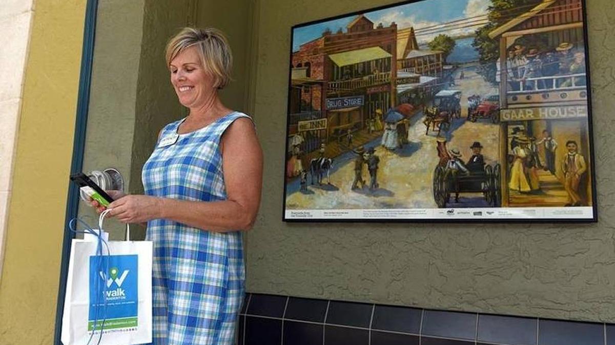Jodi Carroll, Realize Bradenton special projects manager, demonstrates the interactive WalkBradenton.com website on April 19. The site that lets you explore downtown Bradenton’s walkability to 145 businesses, historical sites and public art locations is already drawing in thousands of users.