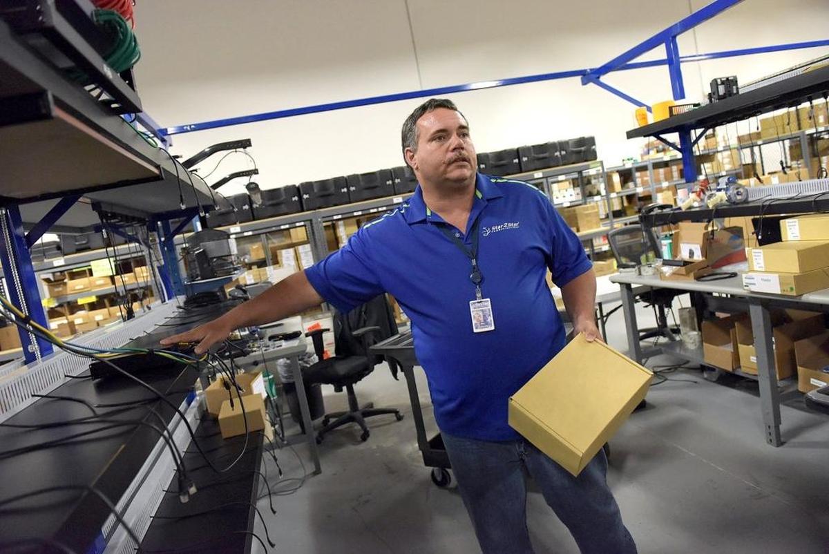 Bill LaMoore, a build specialist, describes how he tests each unit before shipment to clients at Star2Star. Star2Star Communications is one of 67 local companies that have contracted with Manatee County for economic development incentives since 2009.