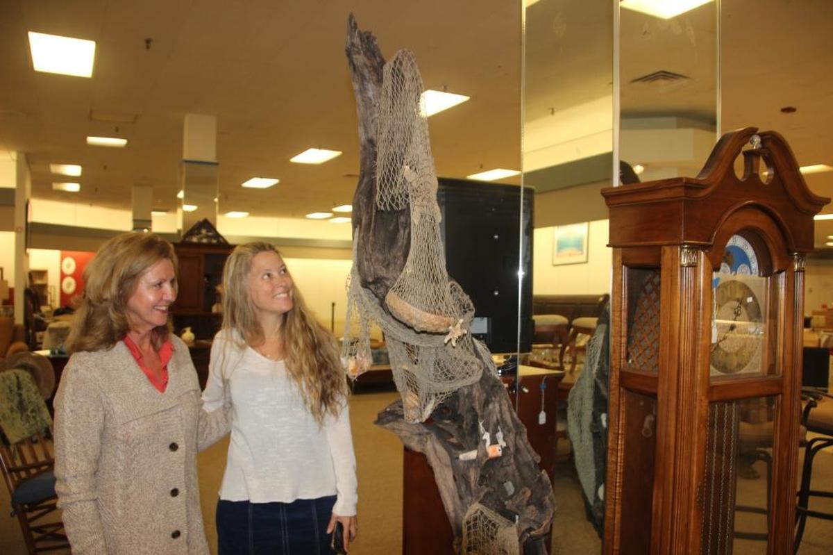 Ruby Davis, left, and Trina Silenzi check out a piece of driftwood sculpture offered for sale at Your Treasure House. The business is set to open Tuesday.