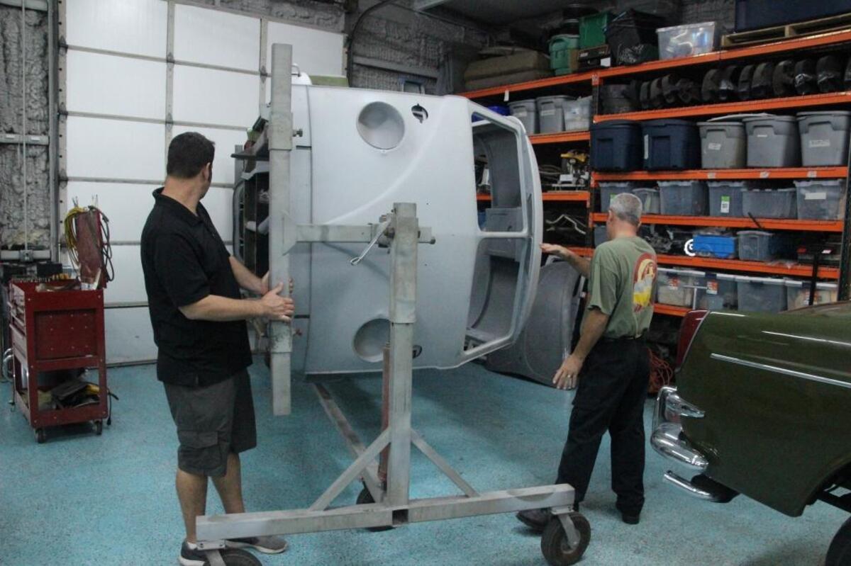 Kip Zimmerman, left, and Jimmy Pollock move a Volkswagen bus that is undergoing a complete rotisserie restoration.