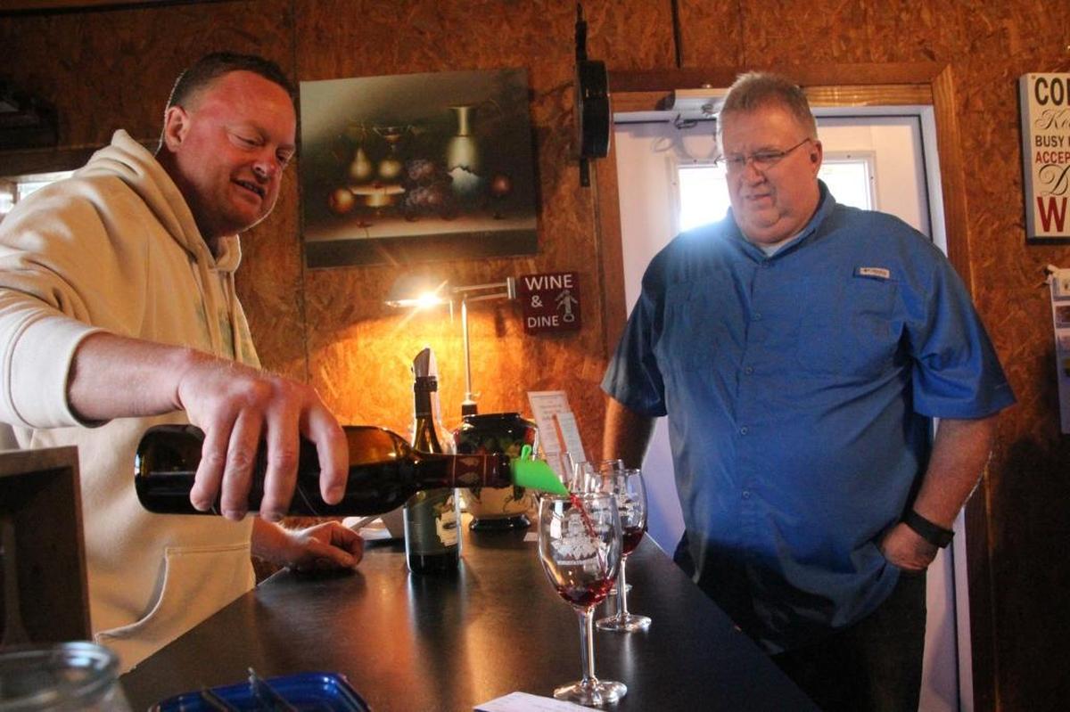 Erik Hall, owner and vintner of Fiorelli Winery, pours for a tasting. Looking on is David Travis. The business is located at 4250 County Road 675 E. in East Manatee.
