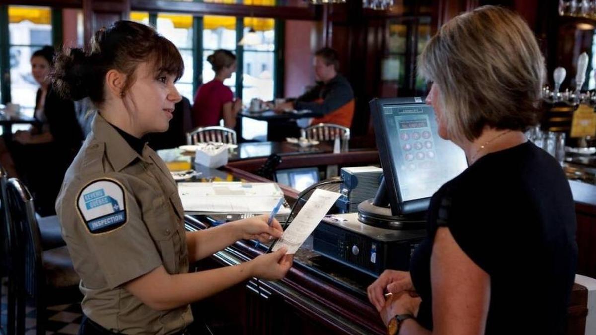 An inspector from Revenue Quebec examines a receipt at a restaurant. Quebec’s tax authorities have gone further than those in the United States in combating sales tax fraud by restaurants and other businesses.