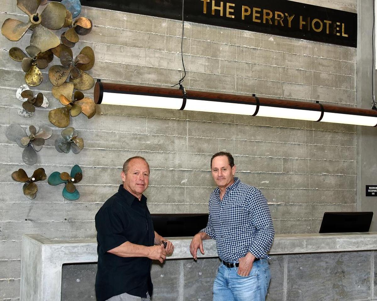 Brad Weiser (left) and Warren Weiser (right) stand near the propeller wall in the lobby of The Perry Hotel Key West on Stock Island.