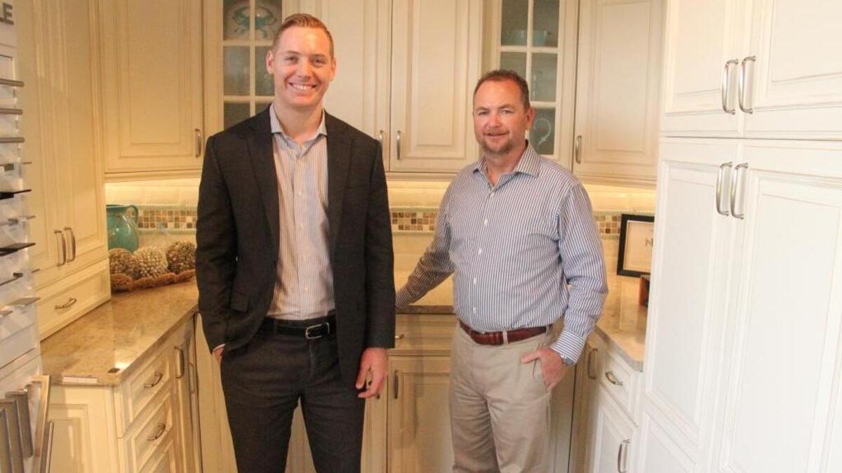 Ernest Gilbert, right, and son Evan stand in one of Gilbert Design Build’s kitchen models in their showroom at 816 Manatee Ave. E. in Bradenton.