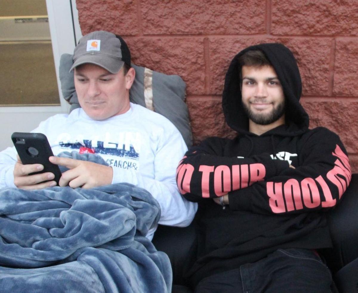 Josh France, left, and Logan Gonzalez camped outside Office Depot, waiting for the store to open to take advantage of a $349 deal for an HP laptop computer.