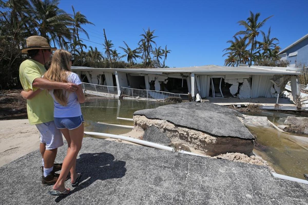 Mike Gilbert and his daughter Brook Gilbert, 15, stand over the remnants of a three-story Sandy Cove condo located in Lower Matecumbe Key in Islamorada.