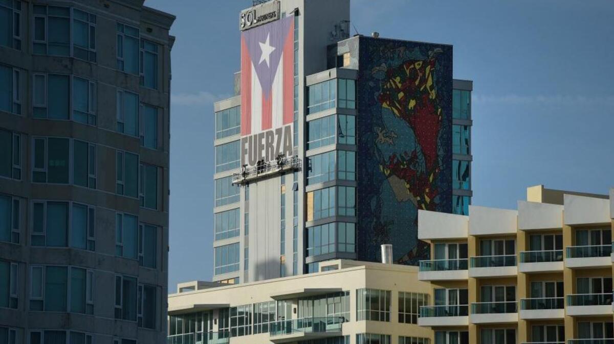 A banner of the Puerto Rico flag with the Spanish word for “strength” hangs on the Caribe Hilton in San Juan, Puerto Rico. In the aftermath of Hurricane Maria, the Caribe Hilton isn’t accepting reservations until 2018.