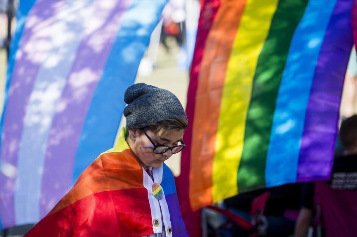 A festival-goer wears a pride flag as members and supporters of the LGBTQ community gather at last year’s Manatee Pride Festival at the Bradenton Riverwalk.