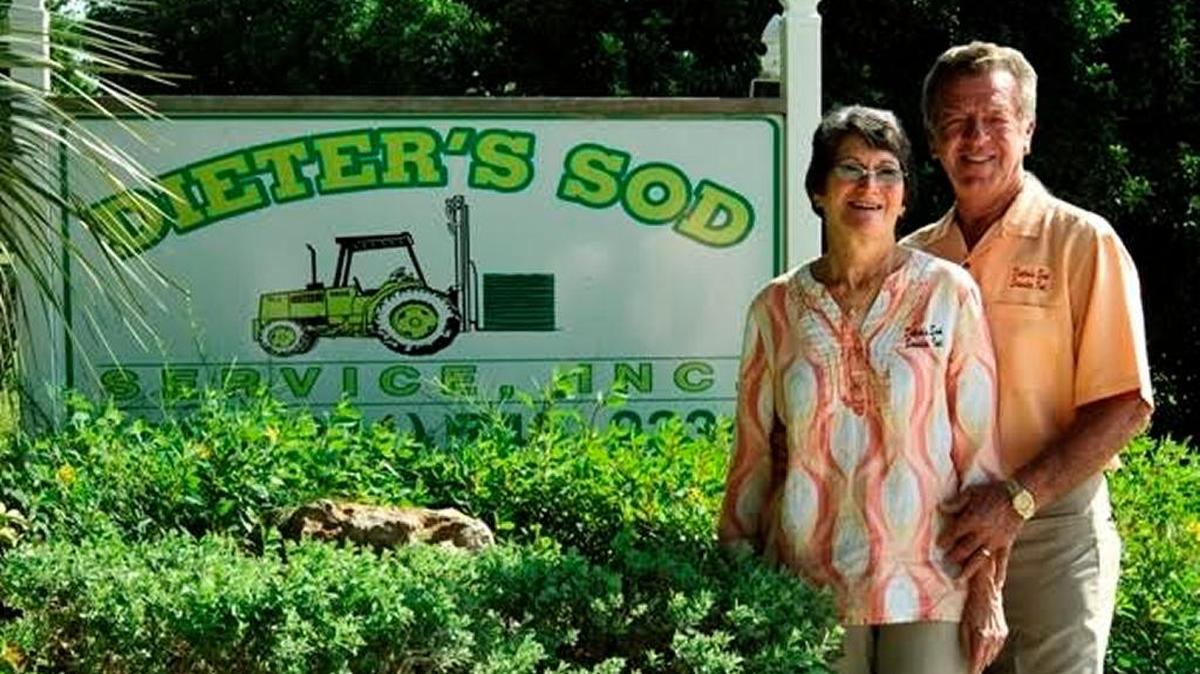 Carole and Dieter Zoellner in front of the Dieter’s Sod & Landscaping business sign.