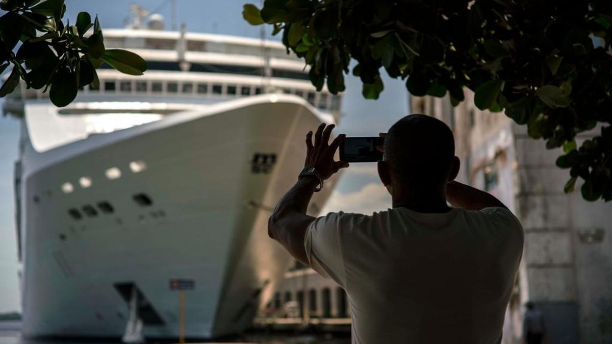 A man takes a photo of a cruise ship in Havana harbor. President Donald Trump’s new Cuba policy will ban Americans from doing business with entities controlled by Cuban military and intelligence agencies, including some 50 hotels. It also will eliminate individual people-to-people visits as an approved category for American travel to the island.