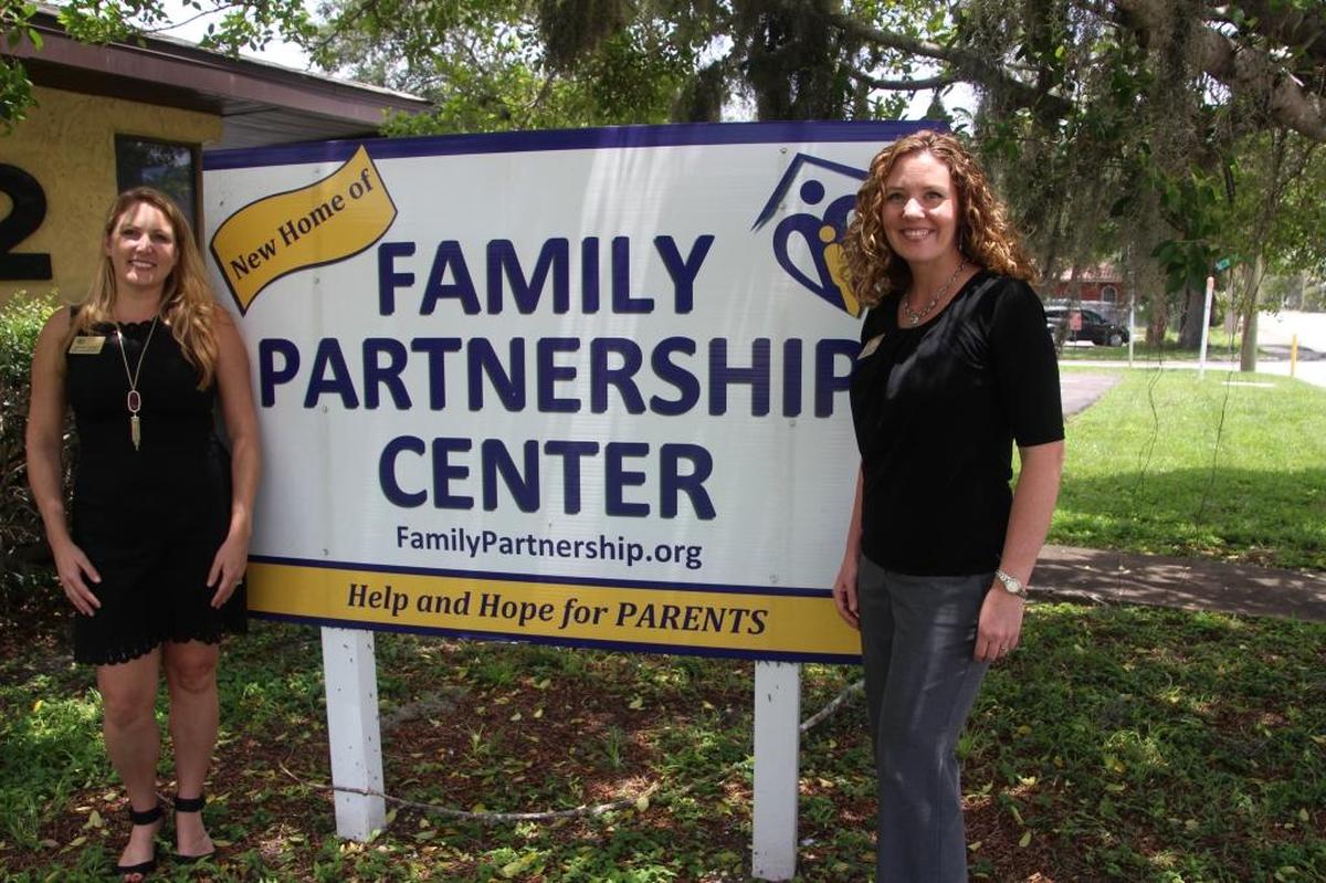 Bridget Harry, left, and Katrina Bellemare stand by the Family Partnership Center sign on Manatee Avenue East in Bradenton. “The appeal of what we do is prevention. We aspire to do good,” Bellemare said.