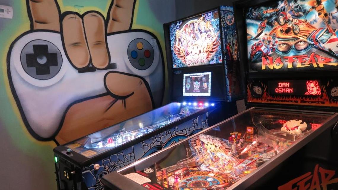 Artwork by local artist Matt McAllister is the backdrop behind pinball machines at Play Arcade and Bar, 436 12th St. W.