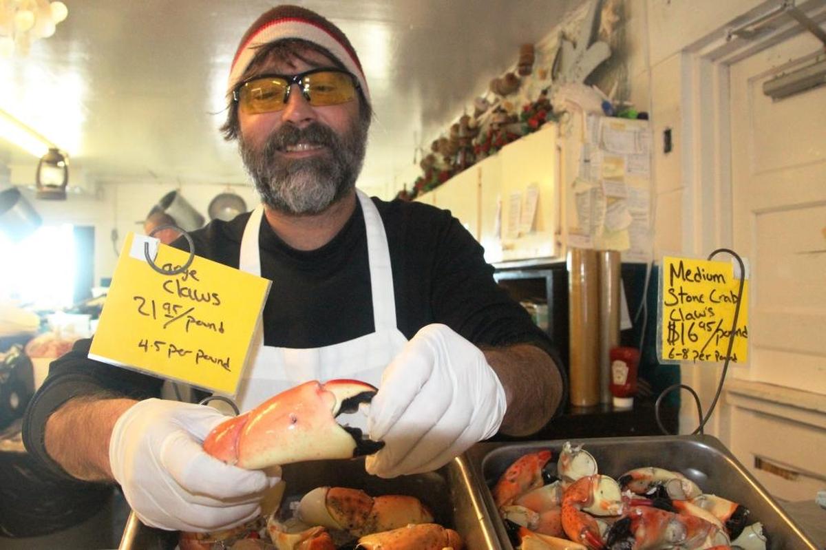 Nick Giles holds a large stone crab claw at Star Fish Company in Cortez. Even though the harvest is down this year, the local seafood outlet has been able to consistently keep them in stock.