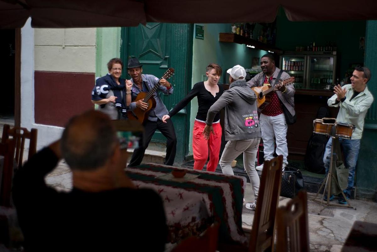 Visitors dance as musicians play at a bar in Havana.