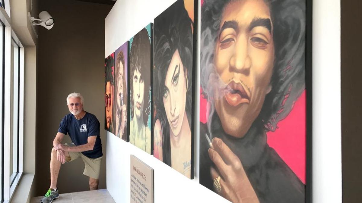 Artist Jack Dowd is shown with prints from his “The 27 Club,” high-profile musicians who died at age 27. The prints face onto Lakewood Ranch Main Street.