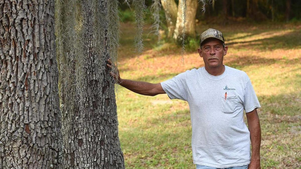 Carl Bergstresser stands beneath a large tree on his property near the Braden River and Linger Lodge. Before he died on July 26, Bergstresser had joined forces with Braden Woods residents who are opposed to a proposed new development nearby which would clear-cut the woods for a housing development.