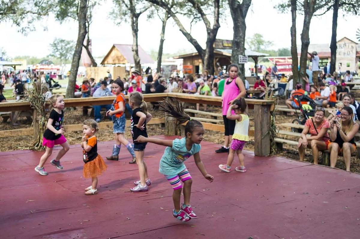 A live band plays music as children dance during the Husander Farms Pumpkin Festival.