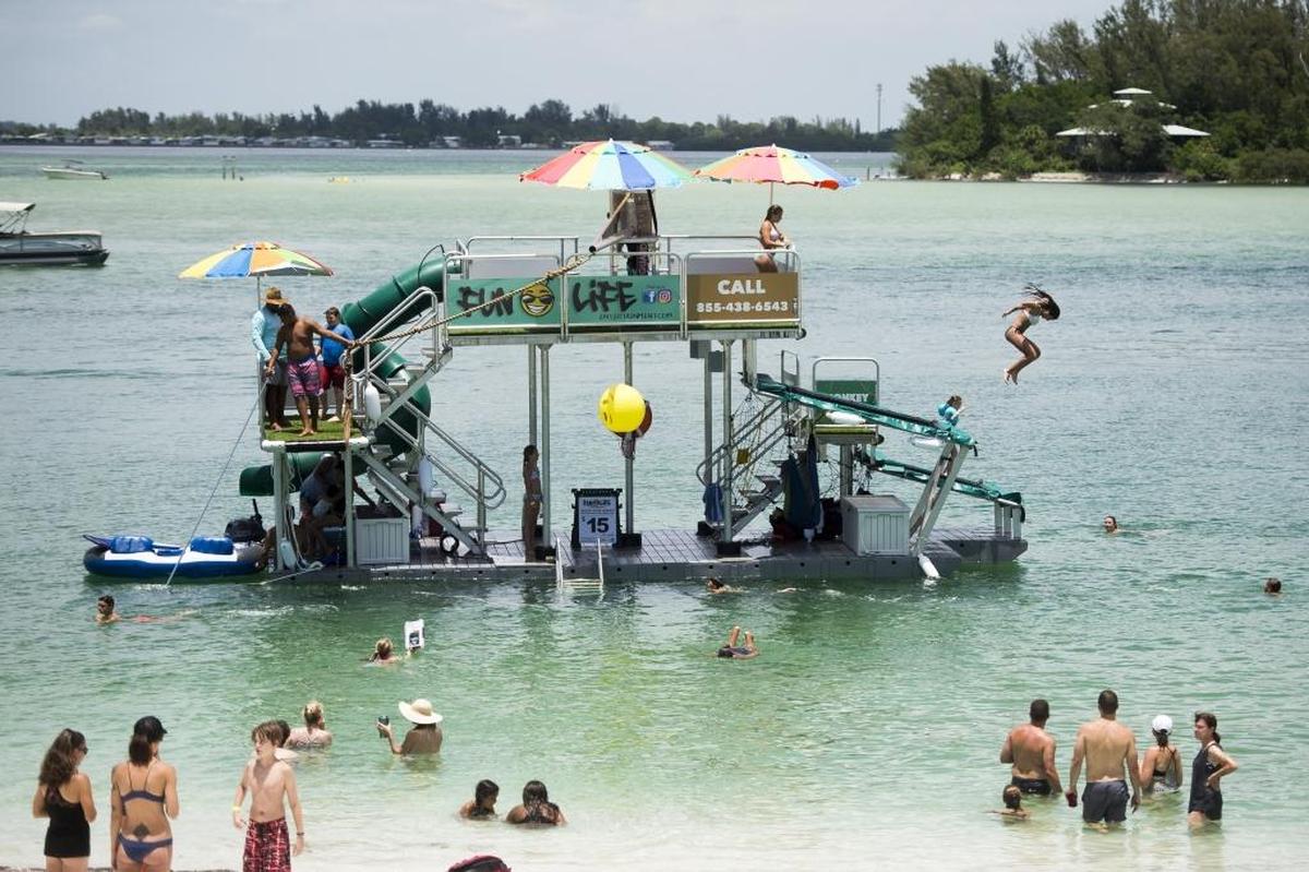 Kids play on a floating jungle gym in the bay south of Longboat Pass on Thursday afternoon in Longboat Key.