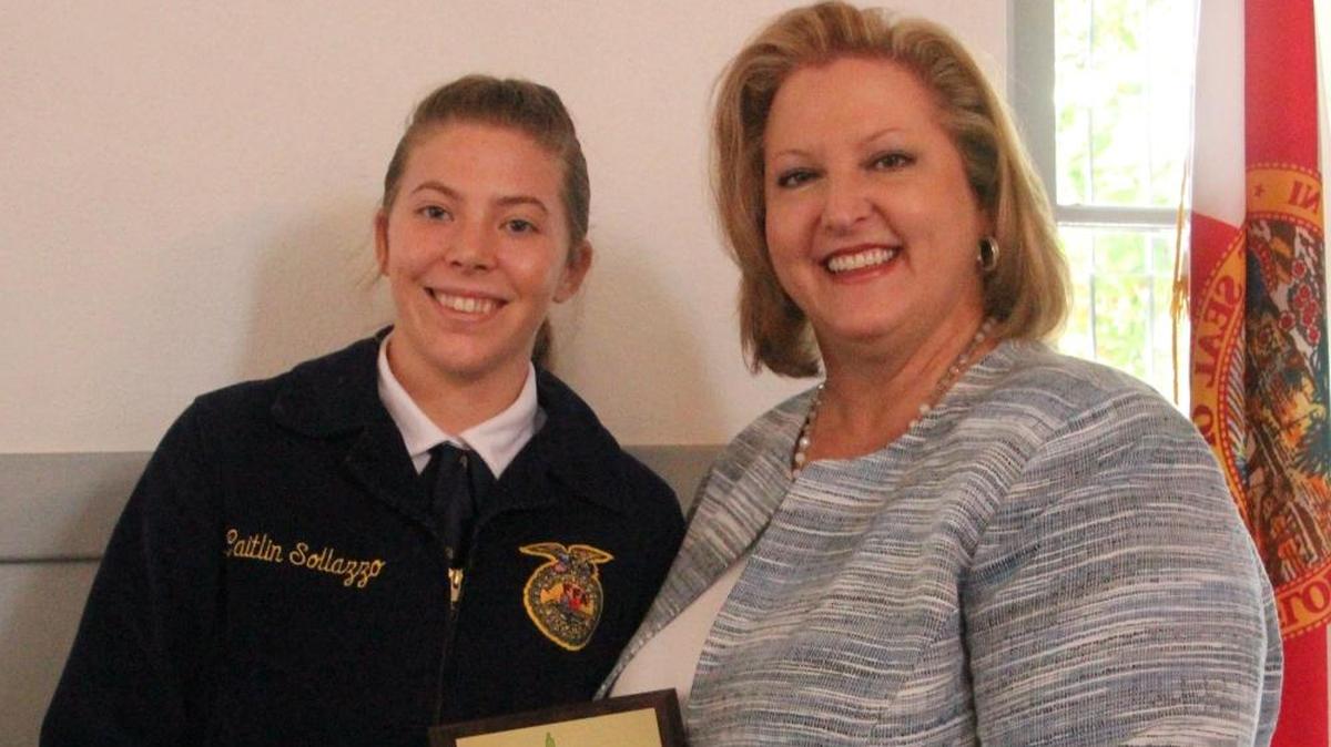 Kelli Kennedy of the Manatee School District presented the first-place award for Farm City Week Essay to Caitlin Sollazzo of Lakewood Ranch High School on Thursday.