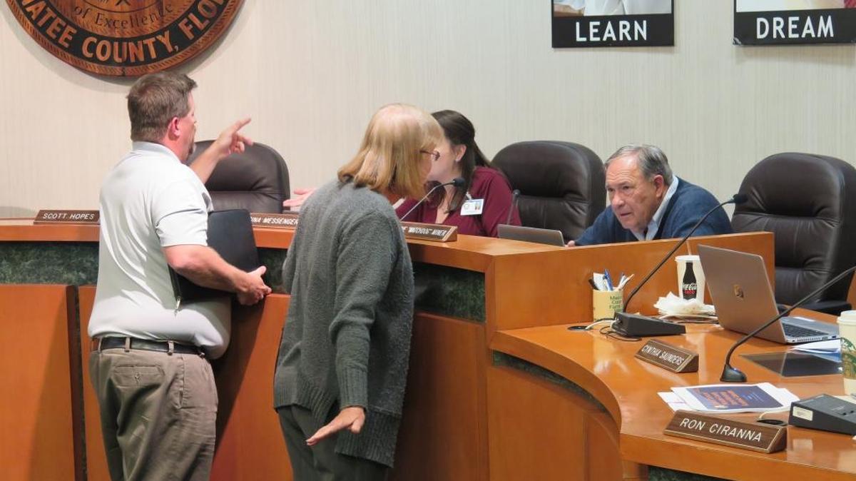 School Board of Manatee County member Dave Miner (right) and Vice Chairman Gina Messenger speak with residents about rezoning the district’s high schools during Tuesday night’s school board meeting.