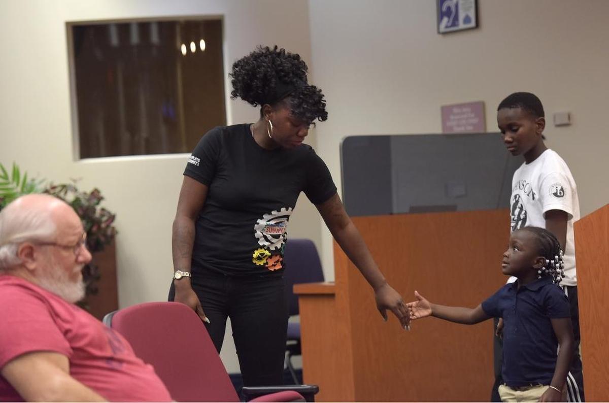Deidre Greene Larkins holds out her hand to Razya Rivers, 4, after addressing the Manatee County Commission during a special meeting Friday to discuss security ahead of the planned march and protests on Monday.