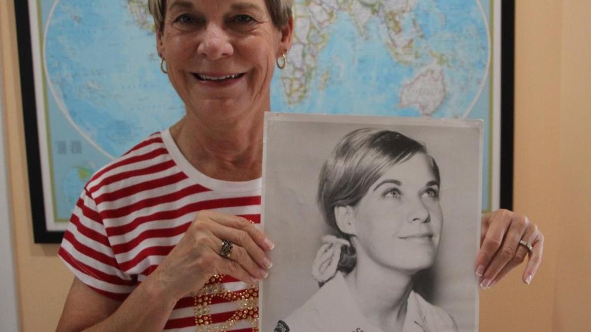 Diane Tucker holds a picture of herself during her service with the American Red Cross’ Supplemental Recreational Activities Overseas program in Vietnam. The women in the program were nickname “Donut Dollies.”