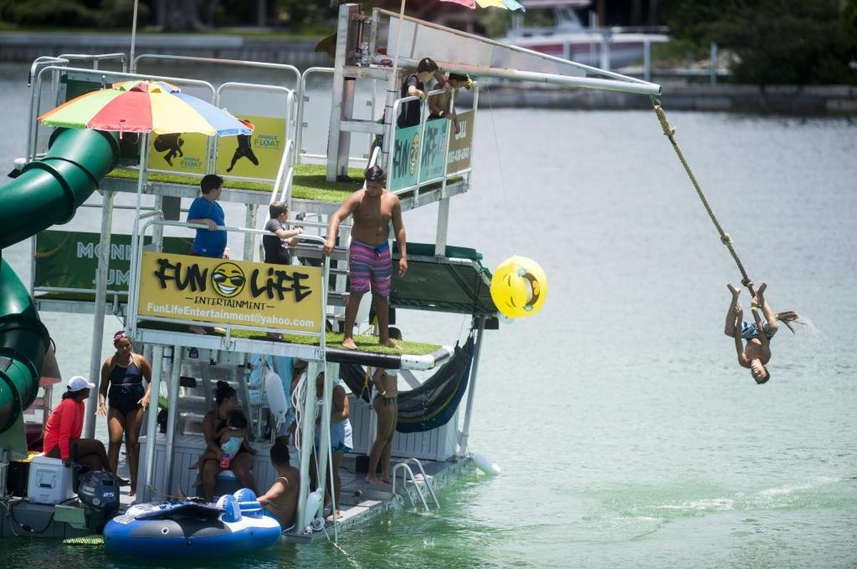 Kids play on a floating jungle gym in the bay south of Longboat Pass on Thursday afternoon in Longboat Key.