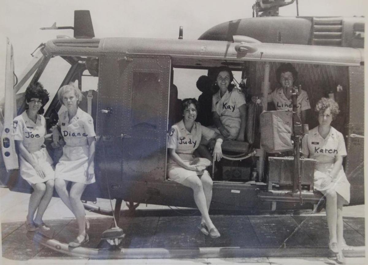 Diane Tucker, second from left, is shown with other Donut Dollies seated on a Huey helicopter during the Vietnam War.
