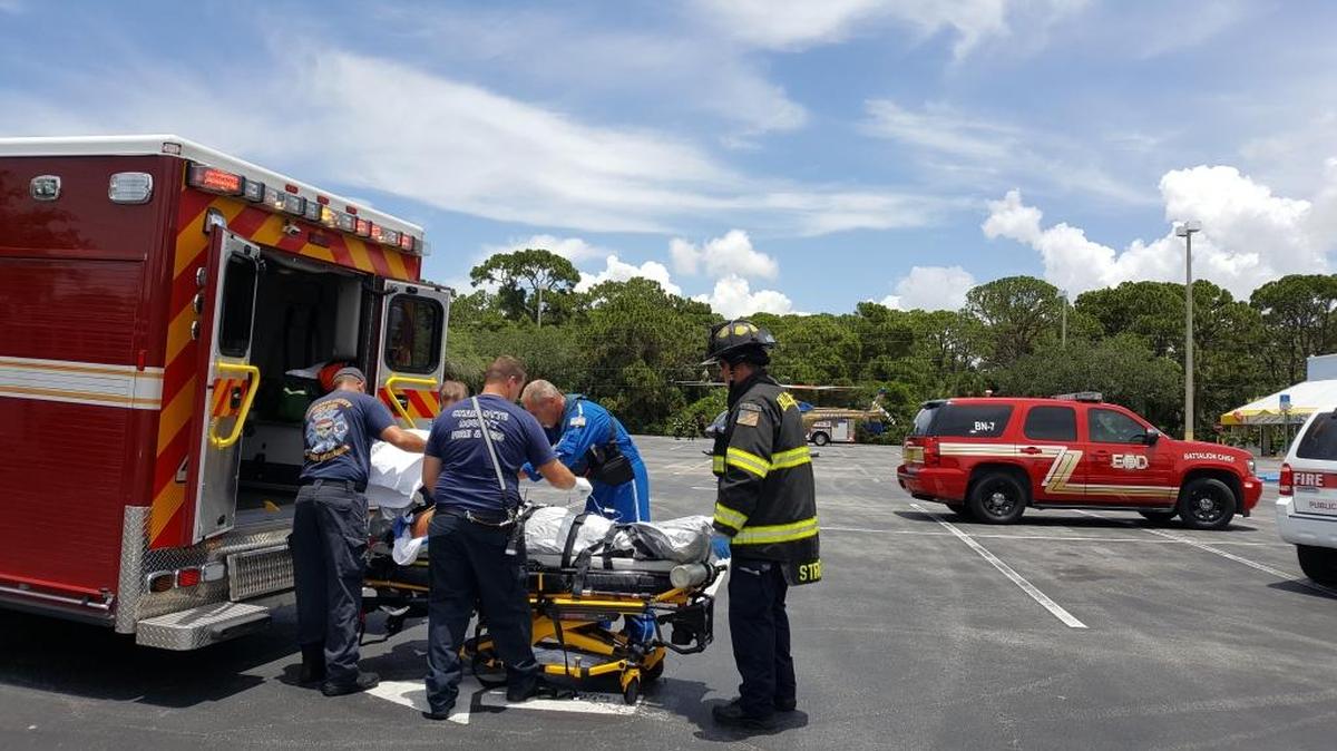 Rescue crews load a man in his 50s into an ambulance Friday afternoon after he was bitten by an alligator while diving for golf balls in Rotonda West.