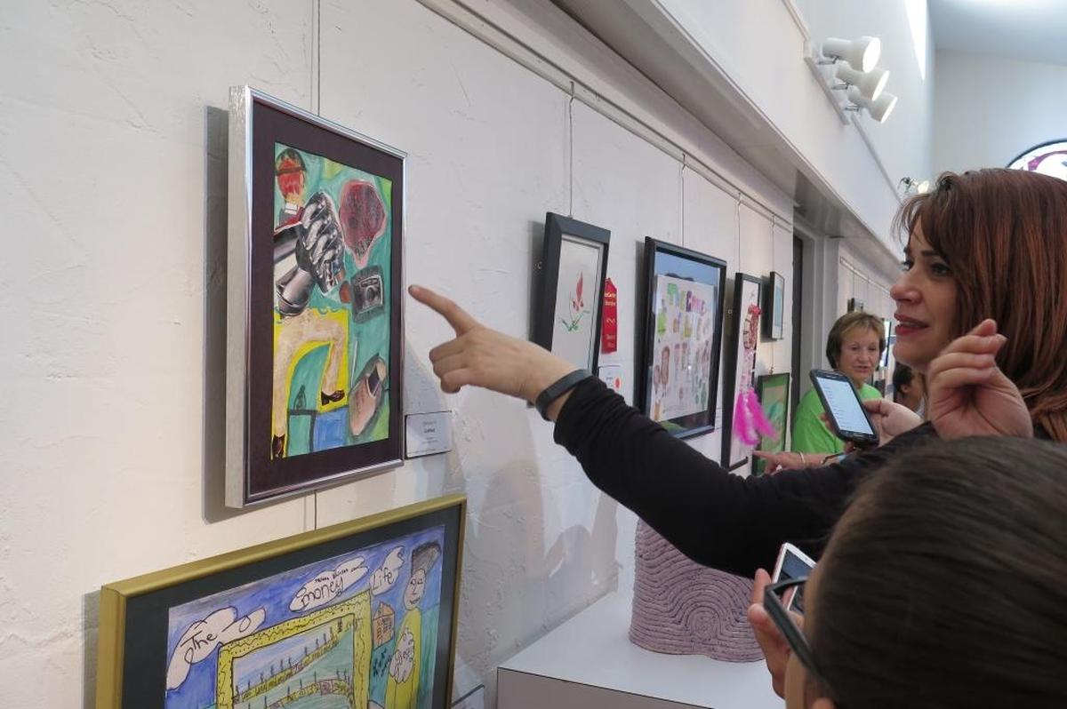 A group stops to admire a piece of student artwork at the fourth annual K-12 Student Exhibit at ArtCenter Manatee.