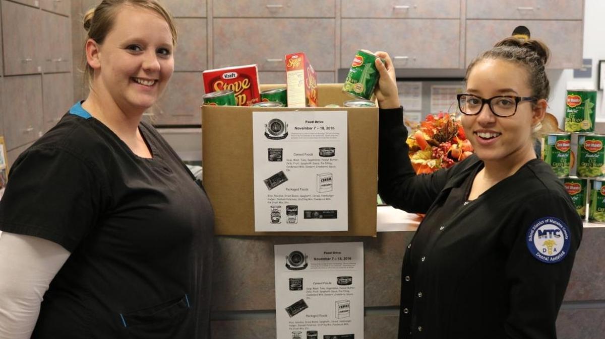 Manatee Technical College dental assisting students Kelsi Yates and Gabrielle Hook, above, are spearheading a food drive to benefit the Mayor’s Feed the Hungry program.