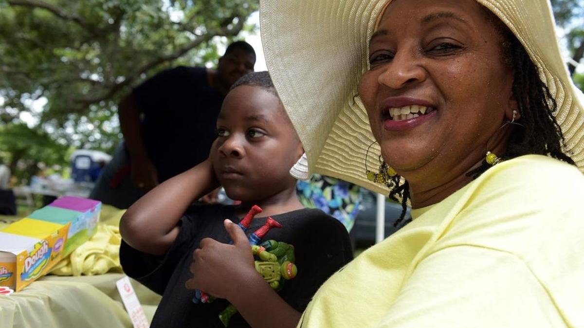 Kathy Mitchell Gainey and her grandson, Cesary Wilbur, enjoy the shade of a tent. Former and current Palmetto residents of what is now uptown gathered at St. Luke's Baptist Church Saturday afternoon for a neighborhood reunion.