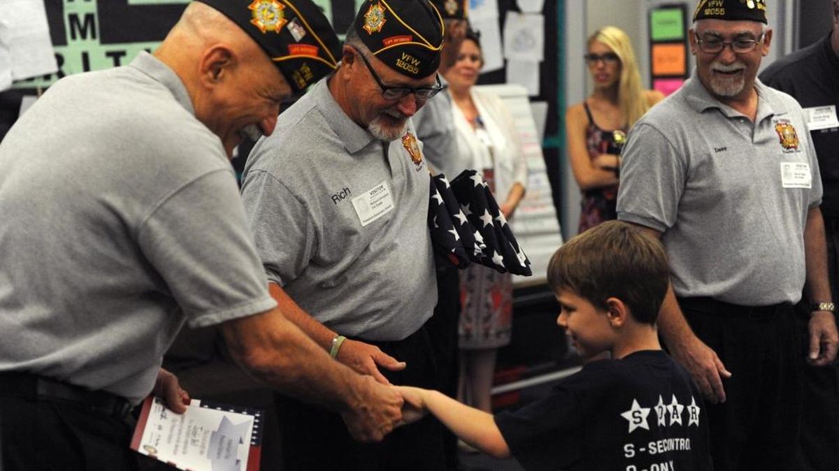 Gill Ruderman, Richard Donoghue, and David Daily, with VFW Post 12055, congratulate Freedom Elementary third-grader Sean Barrett, as he is presented with a certificate after completing a class on American flag history and etiquette Friday at Freedom Elementary. More schools will launch the program this fall. The program is a partnership between Manatee County Veterans Council and the School District.