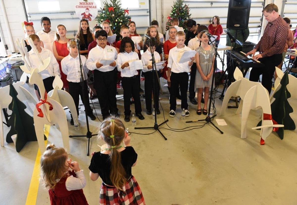 Children sing carols at the annual Flight to the North Pole Christmas celebration for children with illnesses, hosted by the Manatee County Sheriff's Office, Thursday at the Sarasota/Bradenton Airport Fire Station.