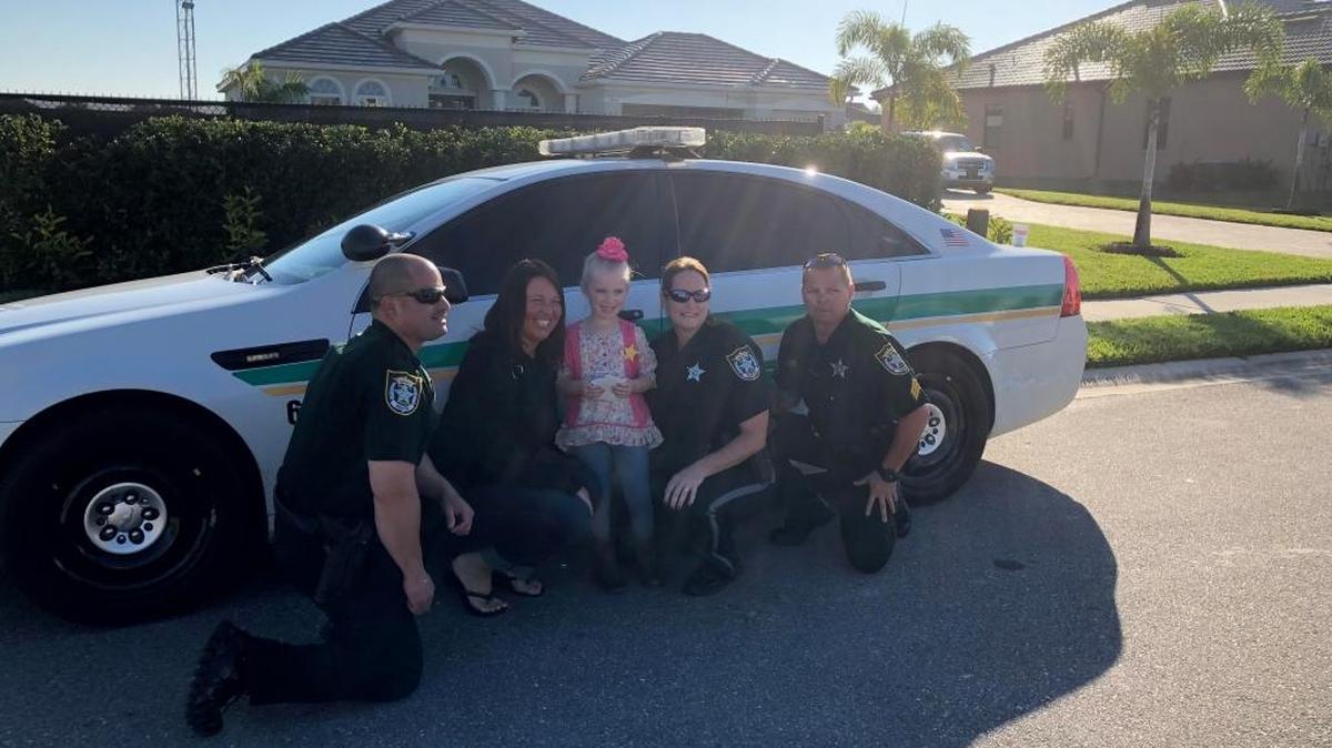 Hannah Rodgers stands with Manatee County deputies after she bought them and other first responders coffee and doughnuts with her money.