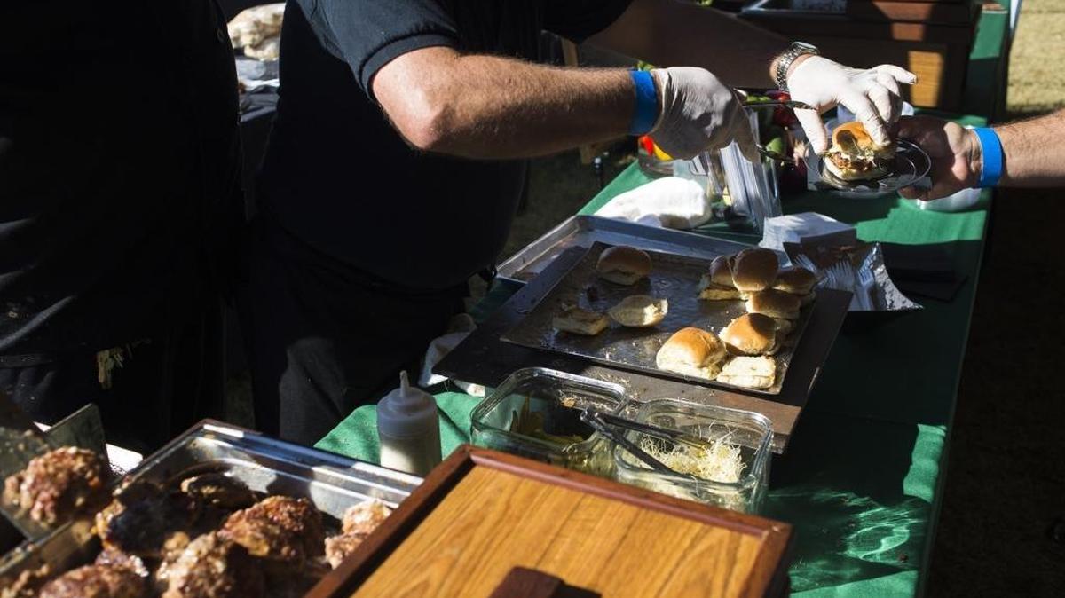 Caterers from Stonewood Bar and Grille hands out sliders to guests during the 15th Annual Suncoast Food and Wine Festival on Nov. 12, 2016, at the Sarasota Polo Club in Lakewood Ranch.