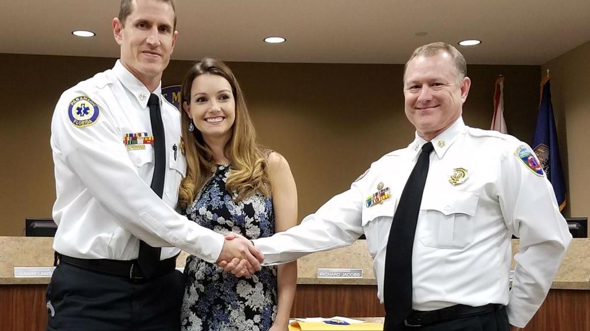 Chief Lee Whitehurst, right, congratulates Deputy Chief William Hall. Hall’s wife, Amber, looks on.