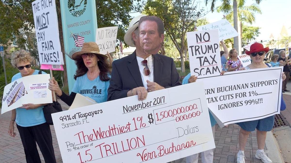 Protestors including members of Indivisible East Manatee and Bradenton rally against a tax bill outside Congressman Vern Buchanan's Bradenton office Tuesday morning.