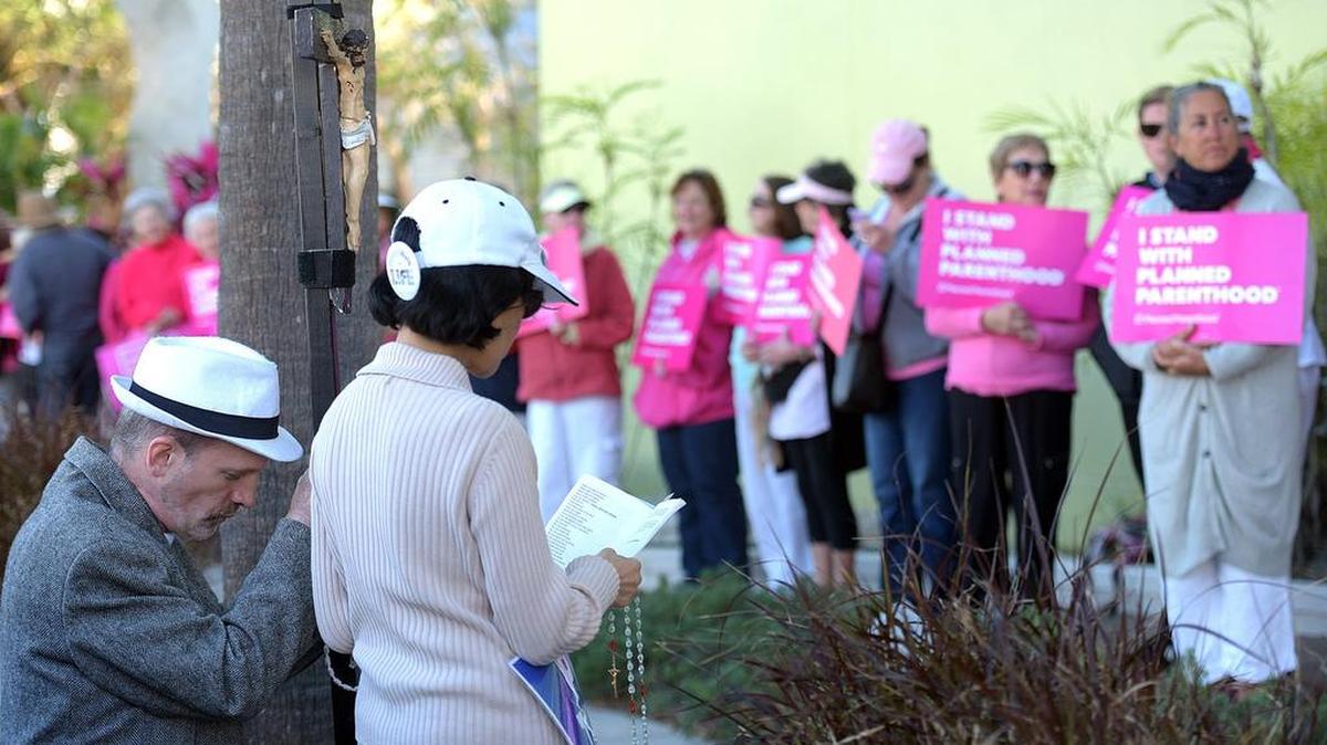 Protestors pray near supporters of Planned Parenthood who stood in solidarity on Feb. 10, 2017 outside the Sarasota clinic, a day ahead of the protests planned across the country on Feb. 11.